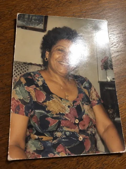 An old printed photo shot at an angle with glare on the face